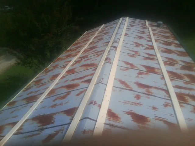 Rusted metal roof panels with new wood purlins before replacement — Storm Damage Roof Repair in Young America by Roofing Brothers