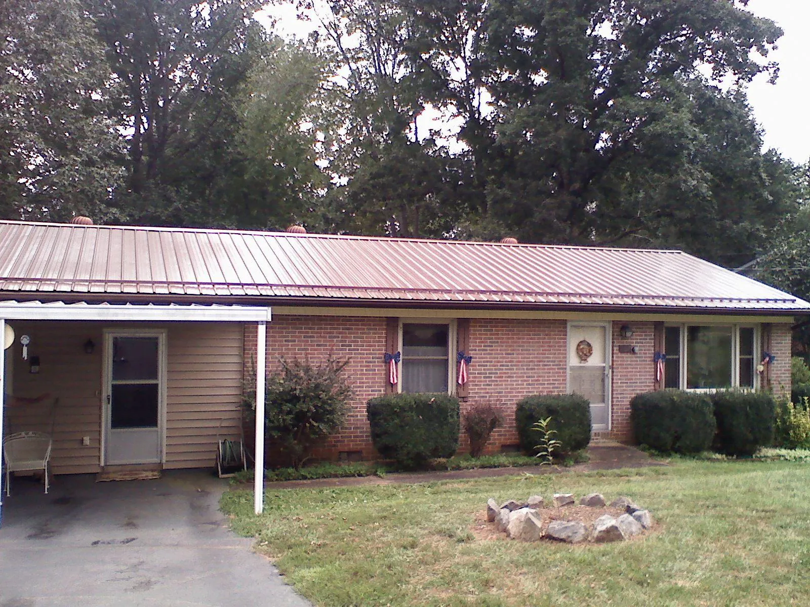 Bronze metal roof and carport on a brick ranch home — Roof Repair work by our crew in Young America